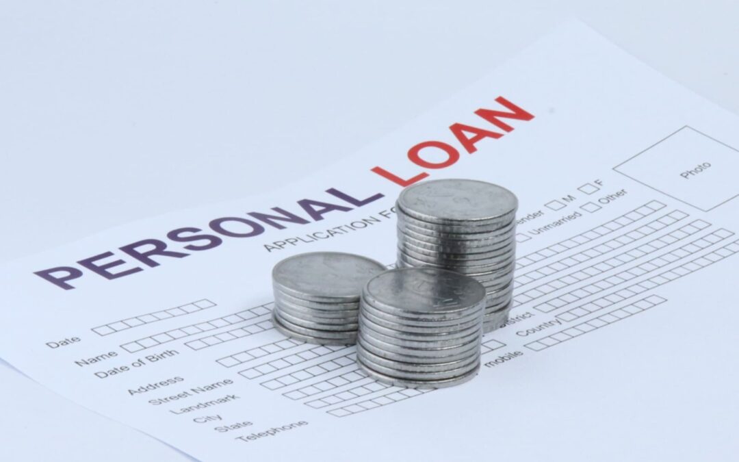 Coins piled up on a loan application to signify personal loan tips