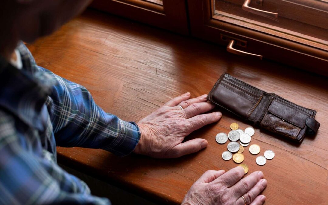 A man looking at his wallet with few coins and wondering how to save money with a low income